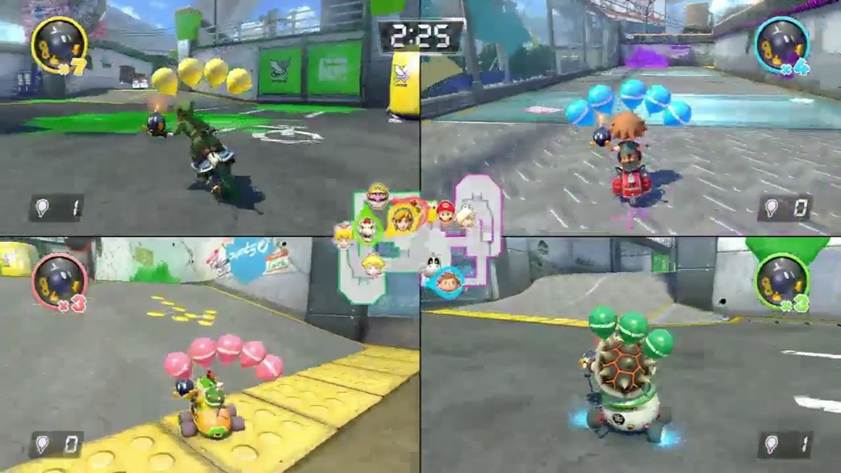 Split-screen view of four players competing in a Mario Kart balloon battle arena, each character driving a kart with different colored balloons attached. A timer and player stats are displayed onscreen, highlighting teamwork for kids and group play for kids.