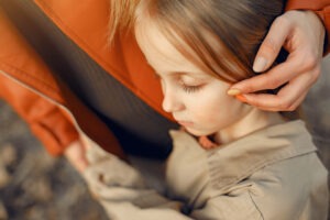 A young child with closed eyes hugs an adult, who gently tucks the child’s hair behind their ear. The scene at Kids Arena, Marbella’s top indoor play center, conveys comfort and tenderness amid family fun and interactive learning in Spain.